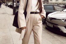 25 a stylish fall outfit with a white top, off-white trousers, a creamy cardigan, black loafers, a black belt and a tote