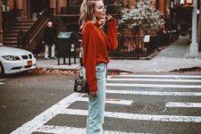 43 an elegant fall look with a rust-colored sweater, bleached jeans, black boots and a small black bag
