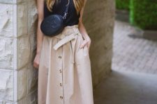 With black sleeveless top, black crossbody bag and black mules