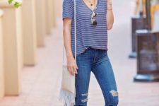 With distressed skinny jeans, fringe bag and brown leather flat sandals