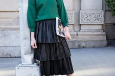 With emerald green sweater and black ankle strap shoes