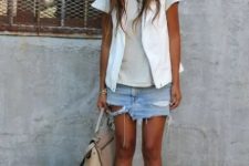 With gray t-shirt, white vest, beige bag and two colored sandals