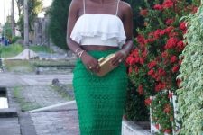 With green lace skirt, golden clutch and golden sandals