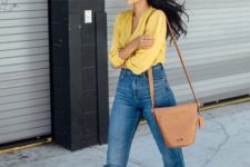 With loose jeans, brown bag and black pumps