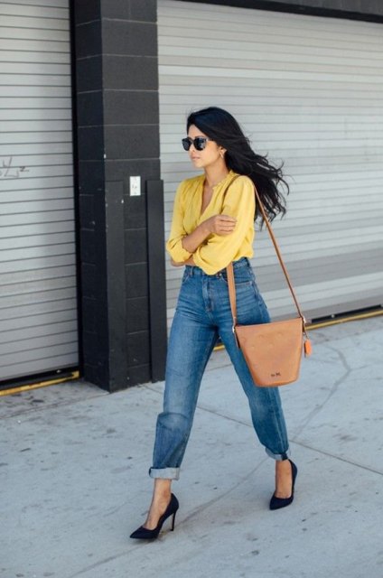 With loose jeans, brown bag and black pumps