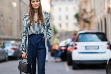 With navy blue high-waisted trousers and black leather bag