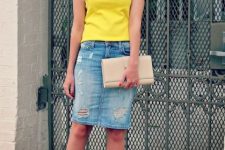With yellow t-shirt, beige leather clutch and beige lace up high heels