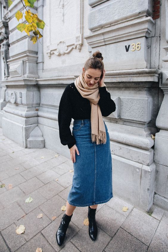 a black jumper, a blue denim midi skirt, black booties, a tan scarf for a stylish and comfy fall look