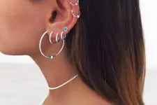 a boho look with stacked helix and stacked lobe piercings all done with bold and cool hoop earrings