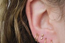 a bold and cool stacked lobe piercing with hoops and tiny studs is a fresh and cool idea to stand out from the crowd