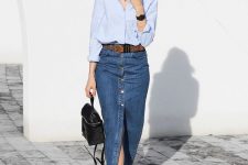a casual outfit with a light blue shirt, a blue button up denim midi, white sneakers and a small black backpack