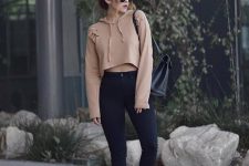 a cropped nude hoodie, black high waisted skinnies, black boots and sunglasses for a bit of edge