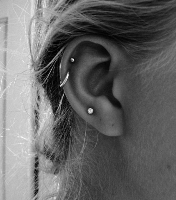 a minimalist look with a single lobe piercing plus a double helix one done with studs and a hoop earring is lovely
