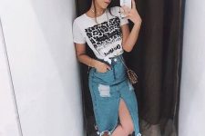 a printed tee, a distressed blue denim midi with a front slit, white sneakers and a printed mini bag
