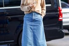 a relaxed and trendy look with a tan jumper, a blue denim midi with pockets, tan boots is simple and chic
