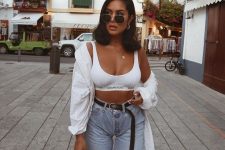 a sexy look with a white micro top, a white shirt, blue denim shorts, white trainers and a bag
