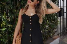 a short black linen sundress on buttons, a woven round bag and layered necklaces compose a sexy and cute look