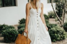 a simple A-line linen midi sundress with buttons, brown strappy shoes, an amber bag and a straw hat for a romantic outfit