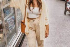 a simple everyday look with a white strapless crop top, yellow striped linen pants, a yellow wide sleeve shirt, an orange bag and blush slipons
