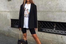 a sporty look with a printed tee, black biker shorts, a black oversized blazer, white socks and trainers and a black bag