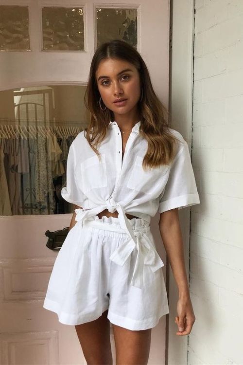 a stylish and simple linen set in white, with a tied up shirt and paperbag waist shorts is all you need for a hot summer