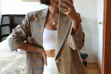 a summer to fall outfit with a white crop top, biker shorts, a plaid grey and yellow blazer plus layered necklaces