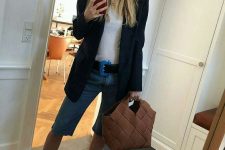 a summer work look with a white tee, blue denim biker shorts, white heeled mules, a woven bag and an oversized black blazer