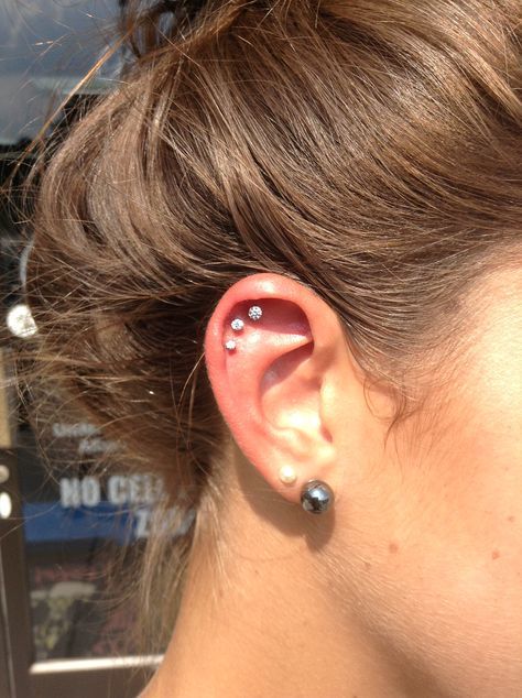 a triple hexlix piercing done with matching stud earrings plus a double lobe piercing done with studs, too