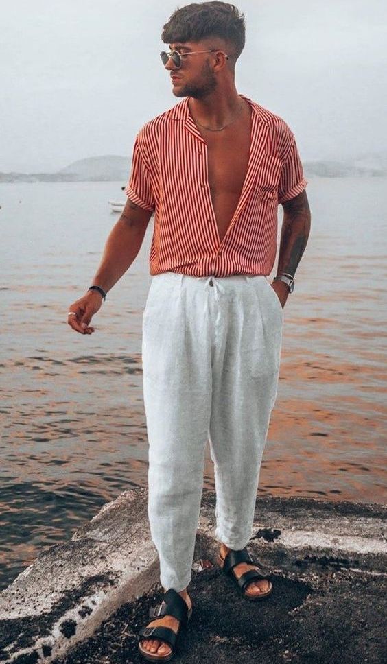 a vacation look with a striped red shirt, neutral linen pants, black buckle sandals and cool sunglasses