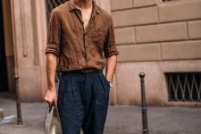 a very relaxed look with a brown linen shirt, navy linen pants, white sneakers is a cool idea to rock on a hot day