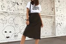 a white printed t-shirt, a black midi skirt, black boots and a black bag for a bold and cool look