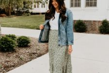 a white t-shirt, a green floral print maxi, amber leather booties, a denim jacket, a hat for a summer to fall look