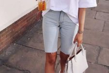 an oversized white tee, distressed blue denim biker shorts, white sneakers and a white bag for a hot summer day
