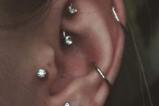modern ear styling with stacked lobe piercings, a conch and a helix one, a tragus and a rook piercing with matching studs and hoops