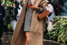 05 a printed black and white blazer dress, brown chunky boots, a tan trench, a brown bag and a tan bucket hat