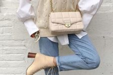 11 a pretty fall outfit with an oversized white shirt, a creamy braided knit vest, light blue jeans, tan heeled boots and a creamy bag