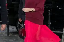 13 an oversized burgundy turtleneck sweater, a hot pink midi skirt, burgundy slouchy boots and a bag by Victoria Beckham