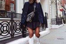 22 a stylish fall outfit with a black top and asymmetrical mini pleated skirt, a navy cropped coat, a printed bag and cowboy boots