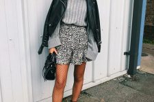23 a grey ribbed long sleeve top, a printed mini skirt, black tights, black boots, a black leather jacket and a bag
