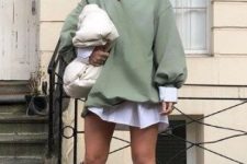 23 a white shirtdress, an olive green oversized sweatshirt, white cowboy boots, a white padded clutch and statement necklaces