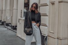 24 an edgy work look with a black crop top, grey sweatpants, black lace up heels, a black oversized blazer and a black bag