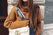 25 a rust-colored chunky sweater, a blue denim overall, a creamy bag for a cozy fall look