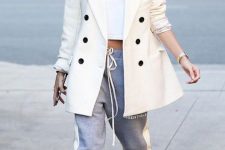 26 Hailey Bieber wearing a white crop top, a creamy oversized blazer, grey sweatpants, white trainers for a comfy look