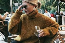 29 a mustard-colored oversized sweater, black jeans and statement earrings that elevate the whole outfit