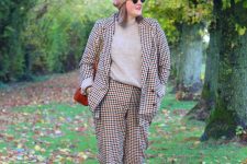 32 a French chic look with a bold plaid pantsuit, a grey turtleneck, burgundy booties, a tan beret, a deep red bag