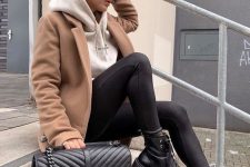 35 a white hoodie, black leggings, combat boots, a tan cropped coat and a black black bag for a comfy look