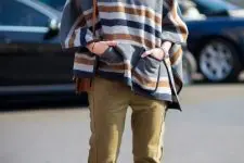With black suede ankle boots, striped poncho and brown bag
