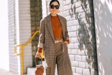 With brown sweater, brown bag, golden belt and pumps