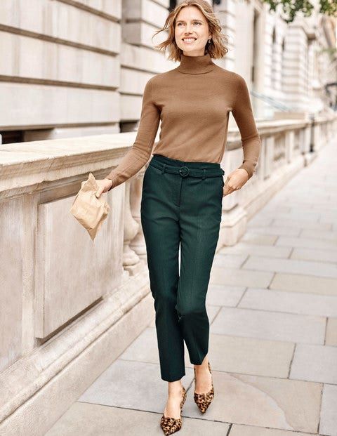 With brown turtleneck, beige clutch and leopard printed shoes