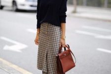 With navy blue loose sweater, brown leather bag and black high boots
